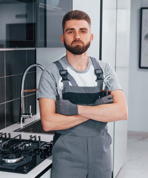 young-professional-plumber-in-grey-uniform-standin-resize.jpg